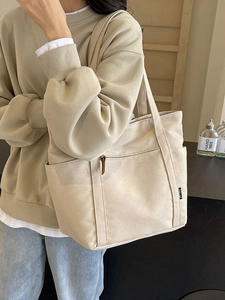 Minimalist beige canvas tote bag for women with wide shoulder straps and large front pocket