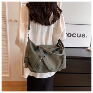 Olive green tote bag with matte texture worn on shoulder in a minimalist indoor setting