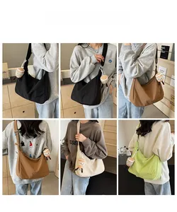 Detail view of large capacity oxford crossbody bags in black, brown, beige, and green colors