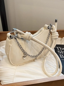 Creamy white crescent handbag with silver chain and heart pendant in a stylish layout