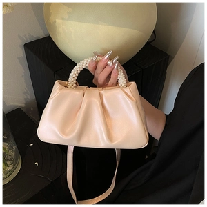 Chic light pink pearl handle cloud bag with pleated leather texture shown in lifestyle setting
