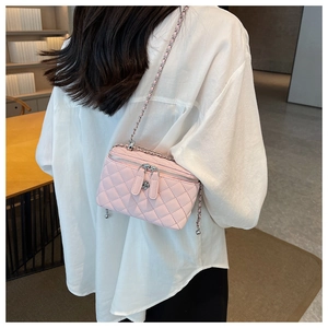 Close-up of pink quilted mini bag with floral zipper and silver chain strap