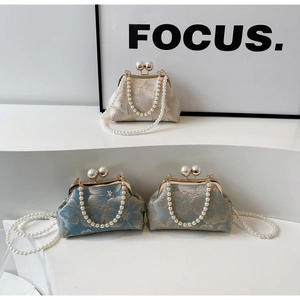 Detailed view of traditional floral embroidery and pearl clasp on Cheongsam style handbags
