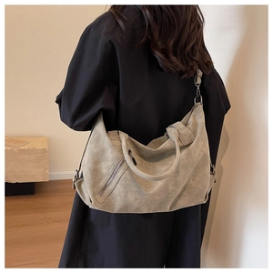 Greenish-grey matte tote bag shown on a model in a minimalist interior setting