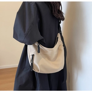 Detailed back view of a beige nylon hobo bag featuring contrasting black woven zippers