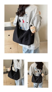 Detail of black nylon hobo bag with adjustable strap and cute plush coffee cup charm