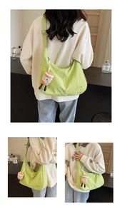 Detail of light green oxford cloth crossbody bag with Hoog embroidery and plush charm