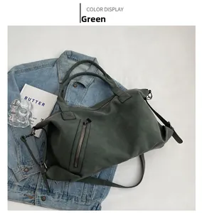 Detail of green large tote bag showing matte texture and functional zipper pockets