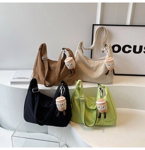 Detail of four colorful nylon hobo bags with adjustable straps and plush cup charms