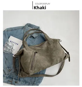 Detail of khaki tote bag with vintage texture, zipper pockets and adjustable straps