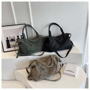 Minimalist tote bags in dark green, black, and khaki on a white geometric stand