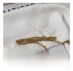 Close-up of the elegant gold chain strap detail on a lace embroidered crossbody bag