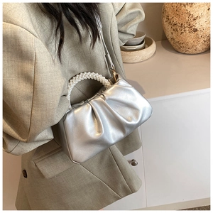 Silver cloud bag with pearl handle and pleated texture worn with a beige suit