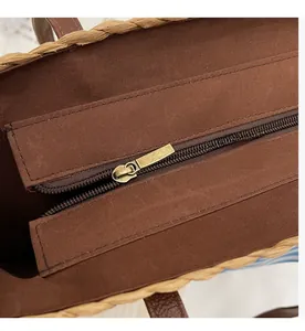 Close-up of smooth brown zipper closure and woven texture on a summer straw bucket bag
