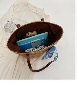 Interior view of raffia tote bag with brown lining, zipper pocket and large capacity