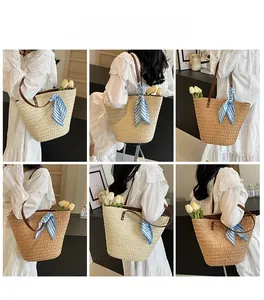 Detail view of woven straw tote bags in beige and tan with leather straps and silk scarf