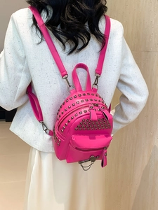 Pink mini PU leather backpack with metallic rivets and chain shown on model back