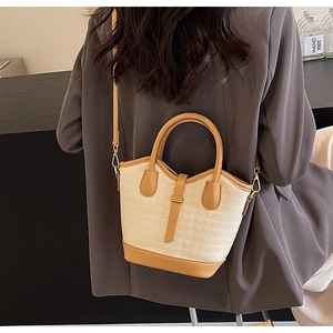 Detail of contrast weave mini bucket bag with leather trim and gold metal lock detail