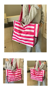 Große pink-weiß gestreifte Strandtasche, aus verschiedenen Winkeln am Model gezeigt