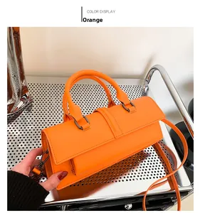 Vue détaillée d'un sac baguette rectangle orange en cuir avec garnitures métalliques