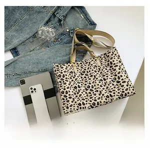 Detail view of leopard print quilted tote bag with textile handles and adjustable strap