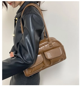Detail view of brown PU leather shoulder bag with double front flap pockets and straps