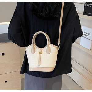 Chic houndstooth bucket bag shown on model in a minimalist home setting