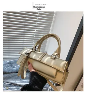 Détail du sac baguette en cuir champagne avec fermoir rétro et poignée supérieure