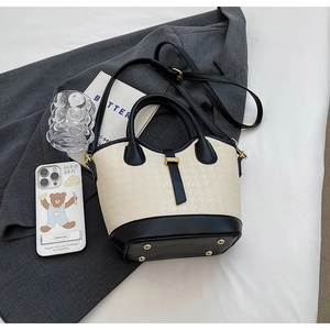Detail view of the contrast color bucket bag showing embossed leather and gold hardware