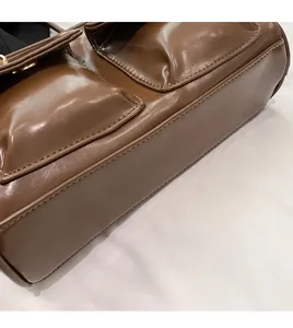 Detailed close-up showing precision hand-stitched seams on dark brown PU leather bag