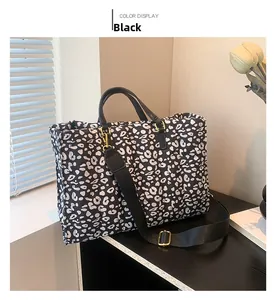 Detail view of large leopard print tote bag with black strap and golden hardware