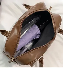 Top view of spacious brown PU leather shoulder bag interior with golden zippers