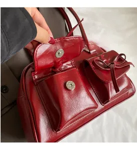 Detail of red wax leather bag with silver magnetic buckle and bow drawstring pocket