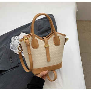 Detailed shot of beige and brown color-block bucket bag with houndstooth texture