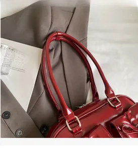 Close-up of a dark red PU leather tote bag with sturdy handles and side pocket detail