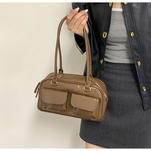 Detail view of coffee brown PU leather bag with two front pockets and golden hardware