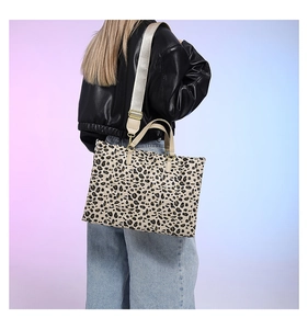 Detailed view of leopard print tote bag with adjustable wide strap on a female model