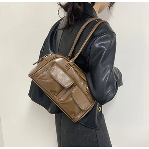 Detail view of deep brown vintage PU shoulder bag with dual front pockets and metal zipper