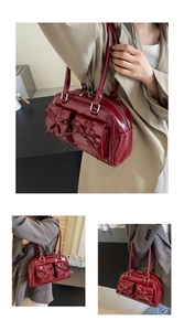 Detail of wine red glossy PU leather bag featuring elegant bow pockets and soft texture