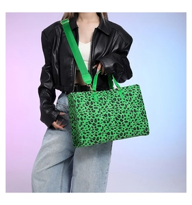 Detailed view of neon green leopard print tote bag with wide shoulder strap on model