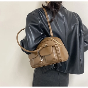 Detailed view of the brown glossy PU leather shoulder bag with dual front flap pockets