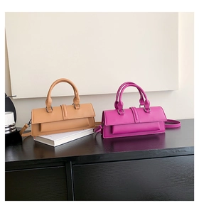 Deux sacs à main rectangulaires violet et beige avec de longues lanières sur bois noir