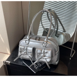 Close-up of metallic silver PU leather bag with delicate bow details and twin handles