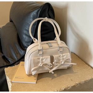 Close-up of cream PU shoulder bag featuring dual bow-knot flap pockets and silver zipper