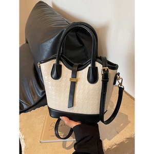 Modern color-block bucket bag in cream white knit texture with black leather accents