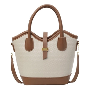 Chic two-tone bucket bag in cream and brown with textured finish and gold metal buckle