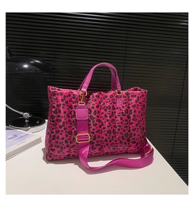 Detailed close-up of fuchsia leopard print quilted tote with gold hardware and wide straps
