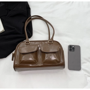 Detail of dark brown PU leather shoulder bag featuring dual front pockets and top handle