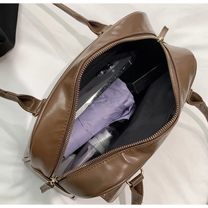 Top view of spacious interior of brown PU shoulder bag with phone and umbrella