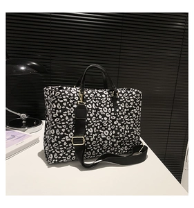 Detail of leopard print quilted tote bag with wide detachable shoulder strap and gold hardware
